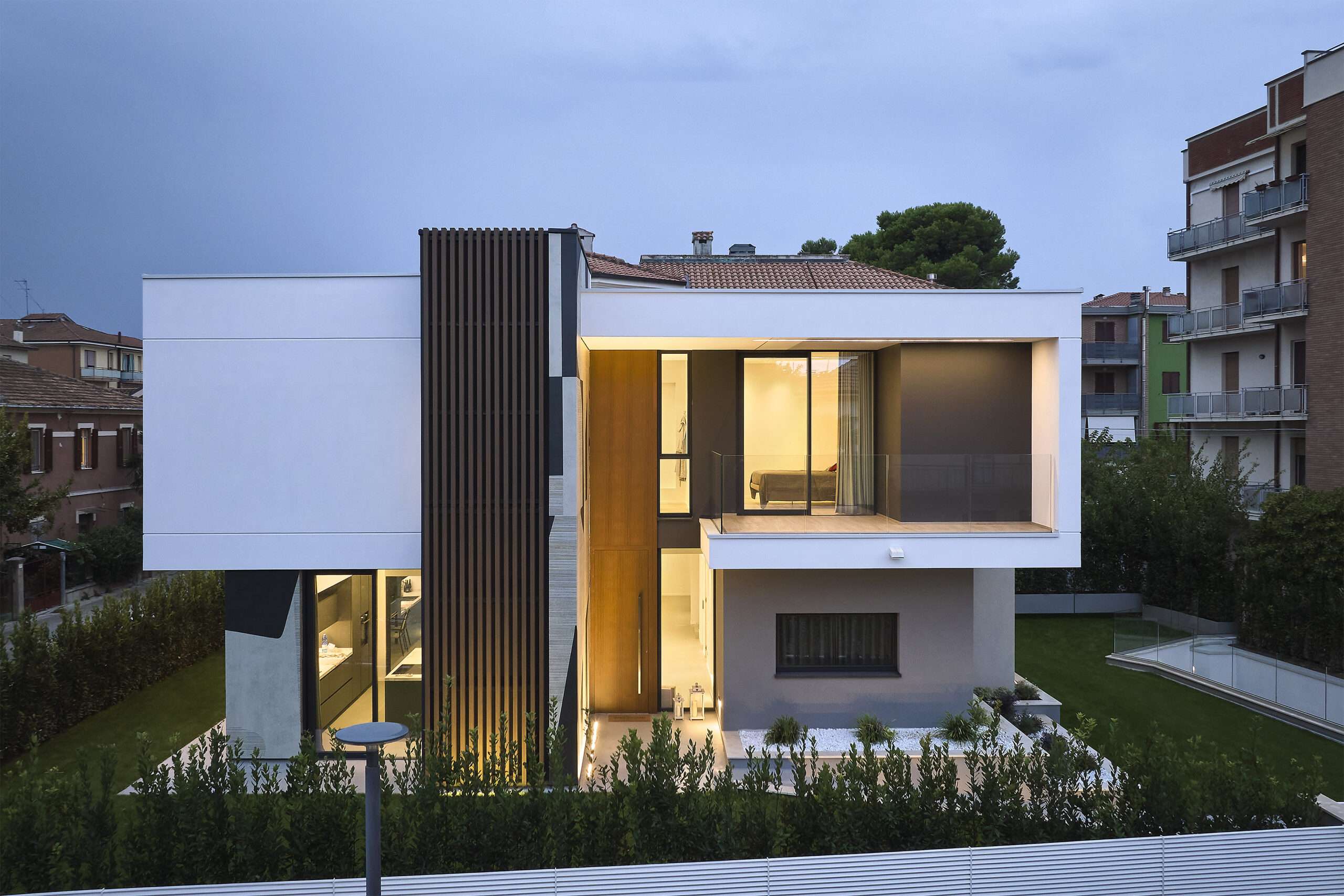Villa con volumi bianchi e legno al crepuscolo
